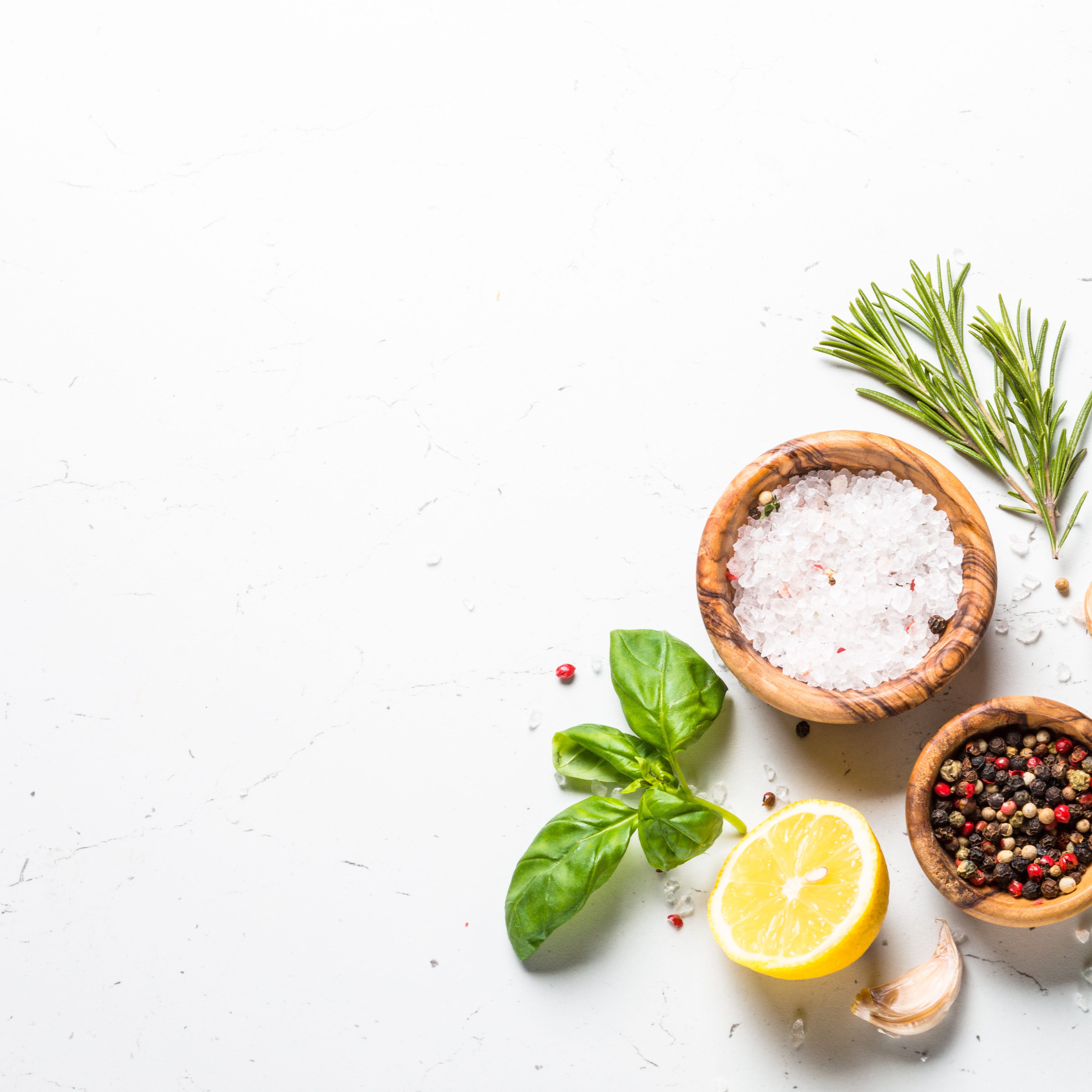 Spices and herbs over white stone table. Food background. Top view, Copy space.